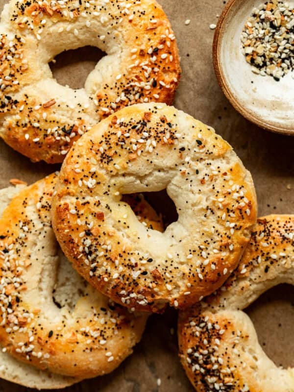 Cottage Cheese Almond Flour Bagels on parchment paper with a small bowl of everything bagel spice on the side.