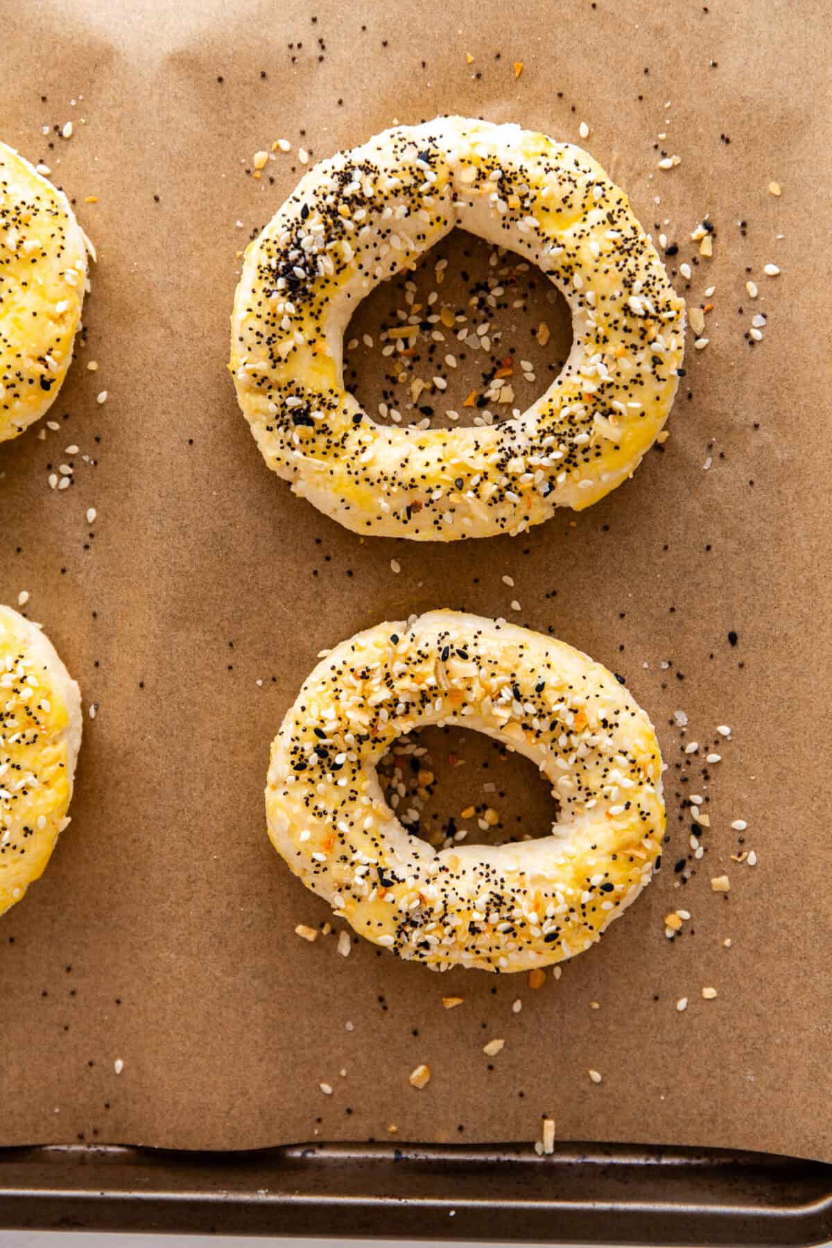 unbaked Cottage Cheese Almond Flour Bagels on a baking sheet topped with everything bagel seasoning.