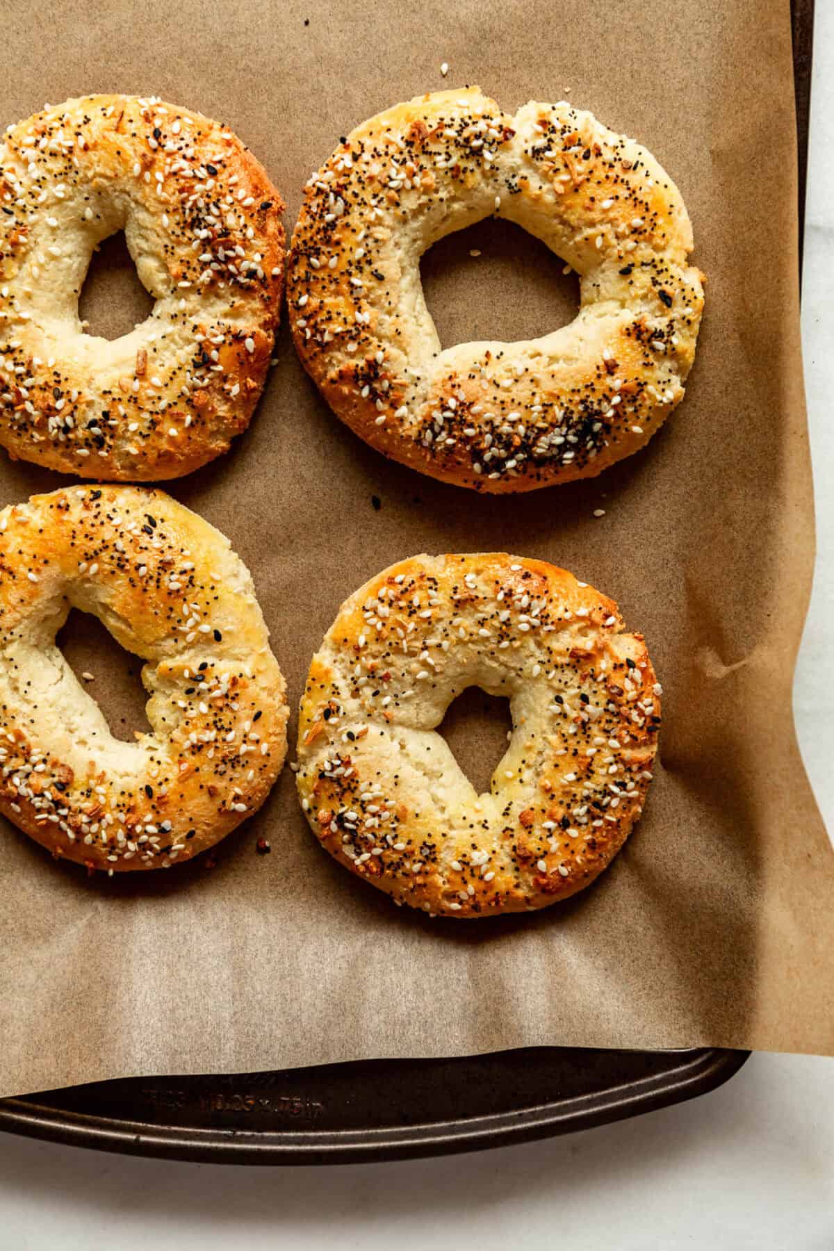 four Cottage Cheese Almond Flour Bagels on a baking sheet with parchment paper.