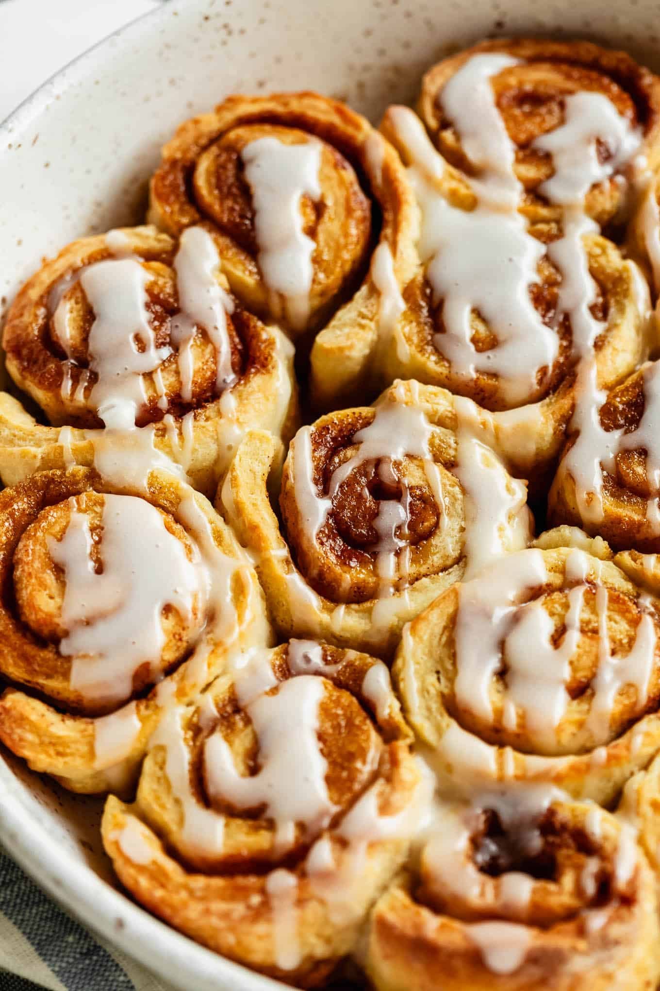 Close-up of glazed cottage cheese cinnamon rolls with icing drizzle.