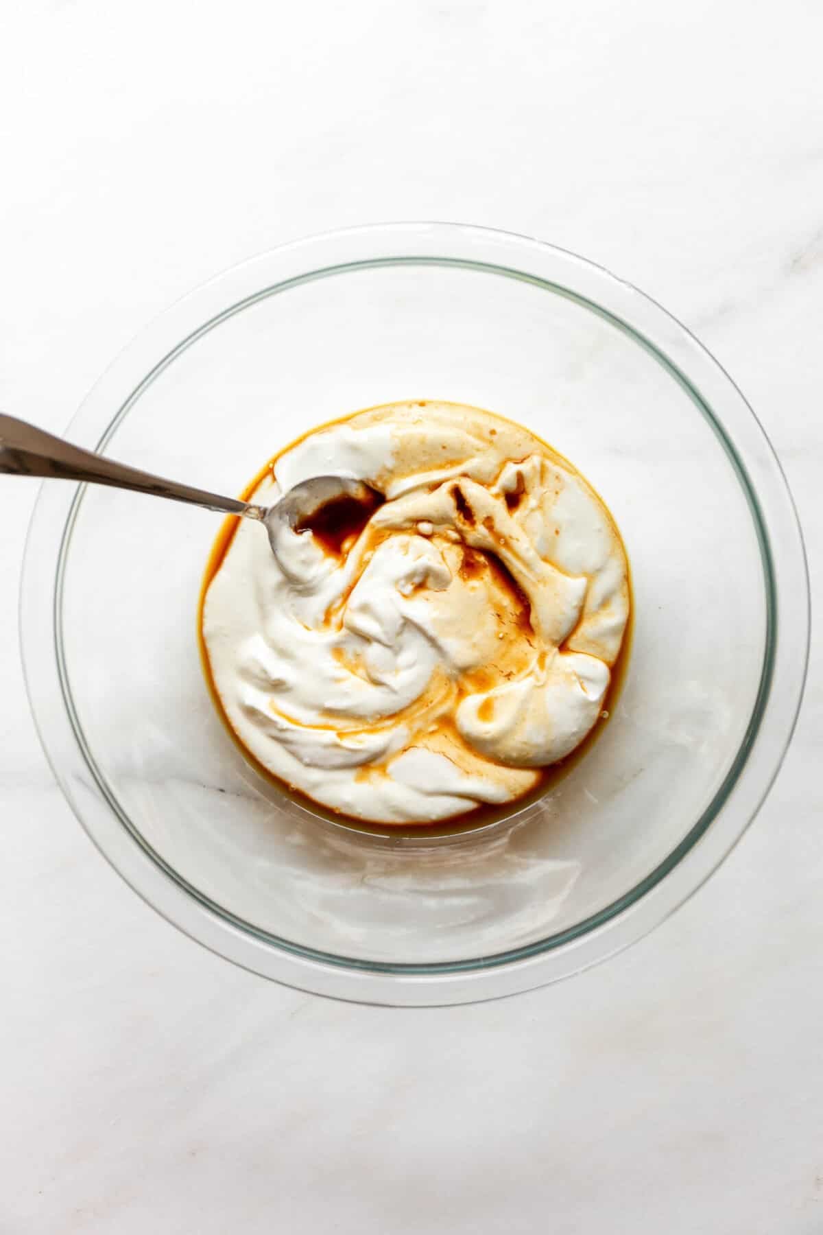 Cottage cheese and vanilla in a clear mixing bowl.