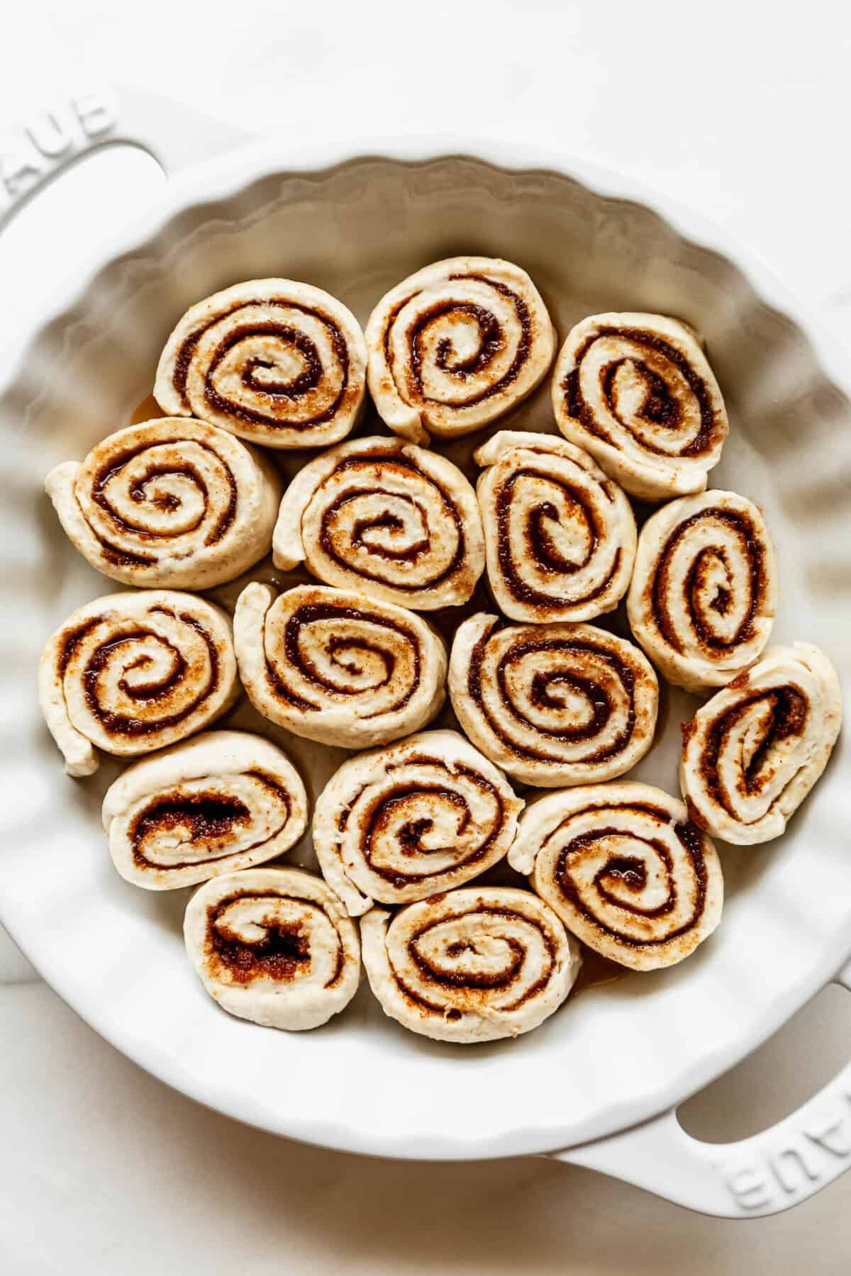 Unbaked cottage cheese cinnamon rolls in a round baking pan.
