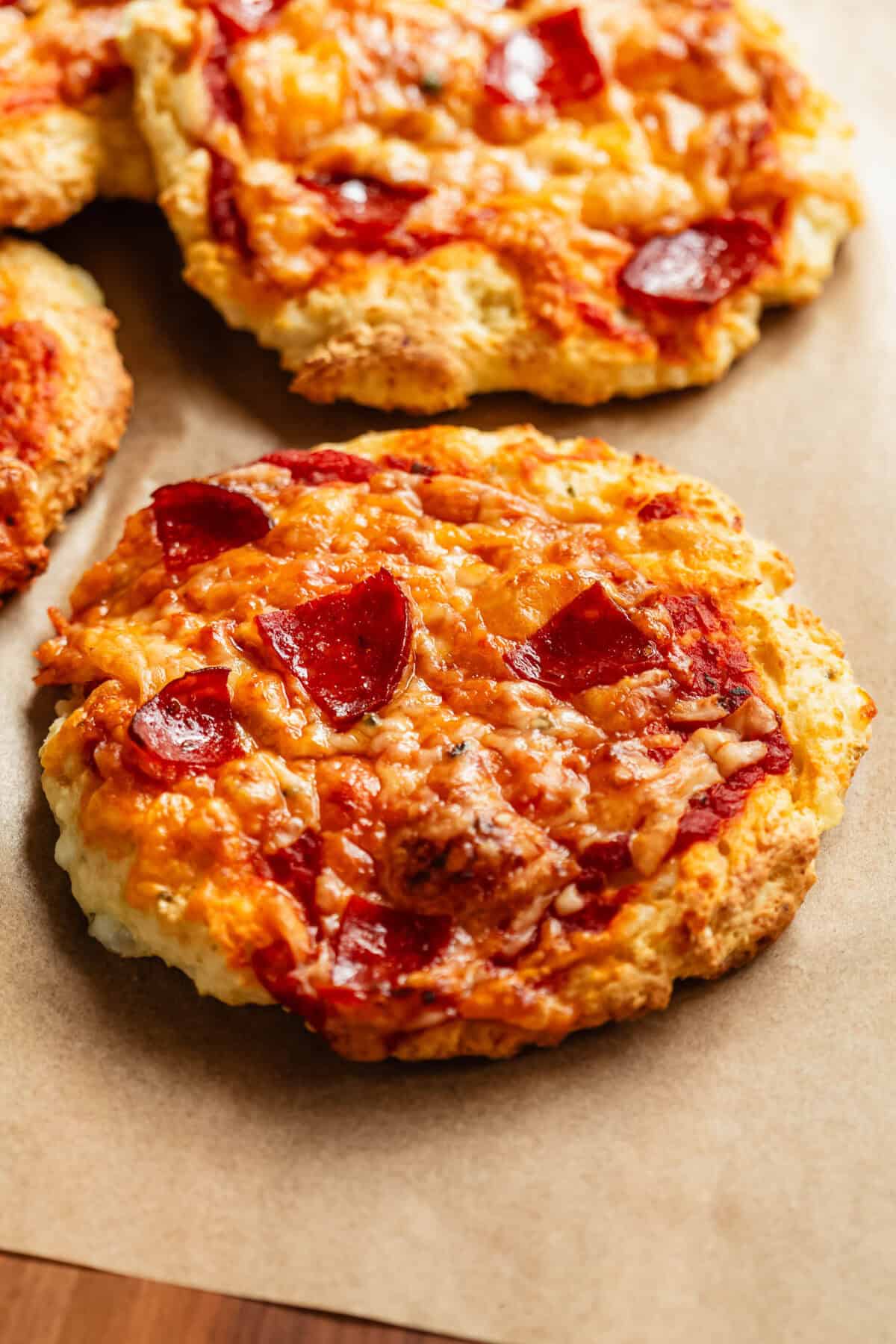 Cottage cheese pizza buns on a wood cutting board.