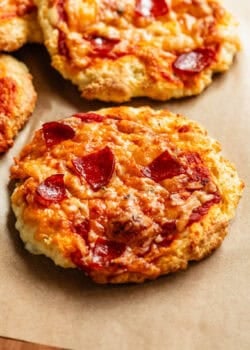 Cottage cheese pizza buns on a wood cutting board.
