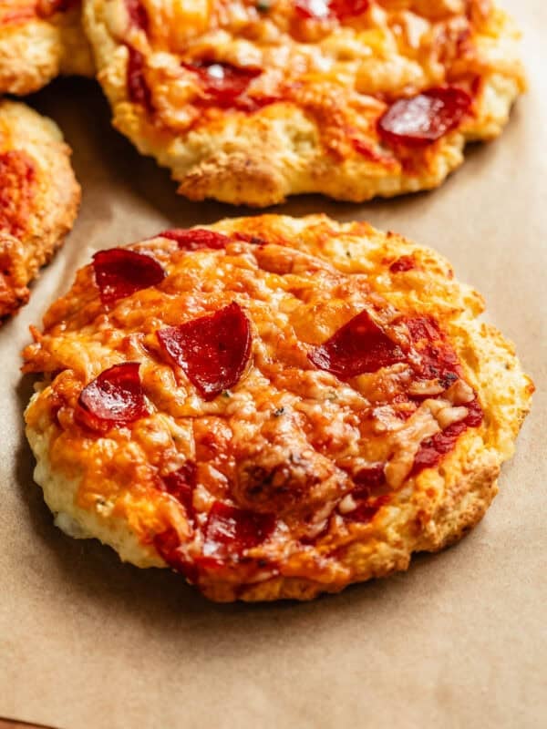 Cottage cheese pizza buns on a wood cutting board.