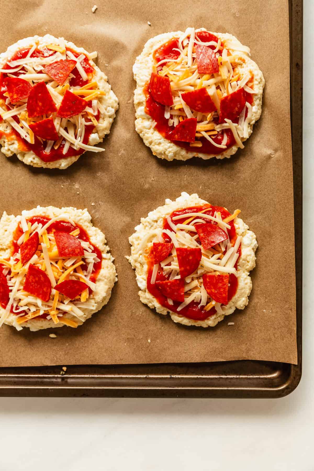 unbaked cottage cheese pizza buns on a baking sheet.