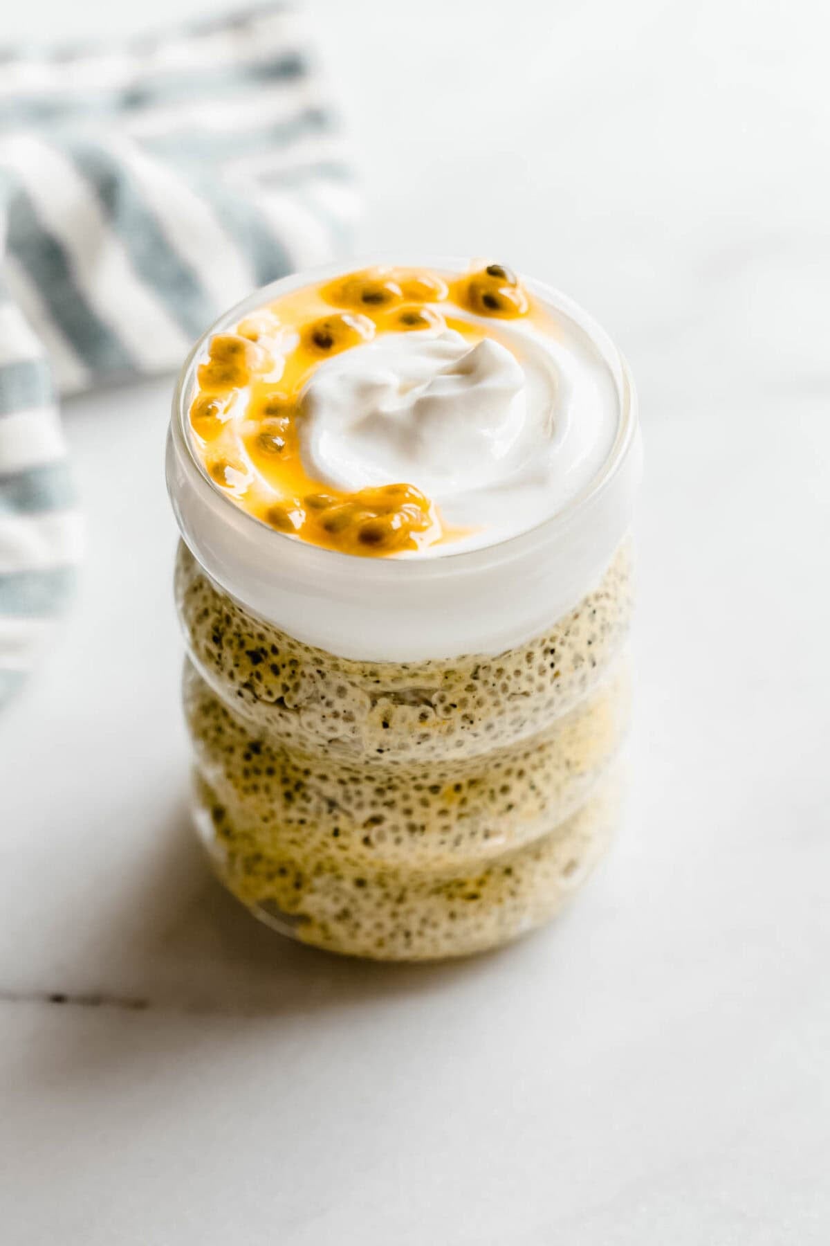 passionfruit chia pudding in a jar topped with yogurt and passionfruit.