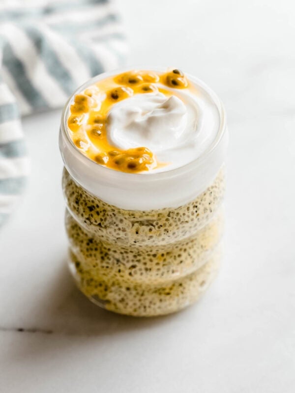 passionfruit chia pudding in a jar topped with yogurt and passionfruit.