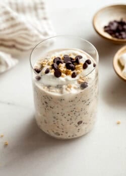 A jar of smores overnight oats topped with graham cracker crumbs and chocolate chips.