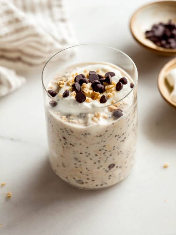 A jar of smores overnight oats topped with graham cracker crumbs and chocolate chips.