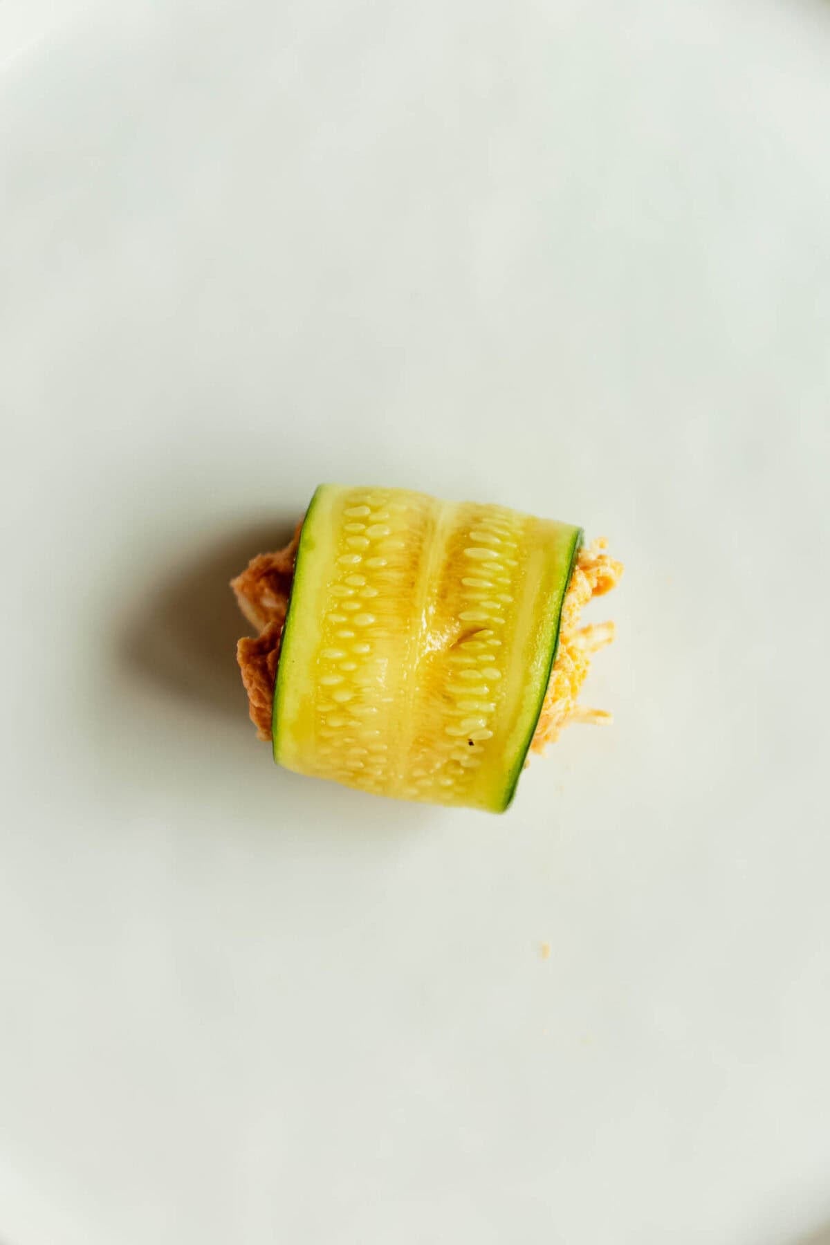 A rolled up sliced zucchini filled with buffalo chicken filling.