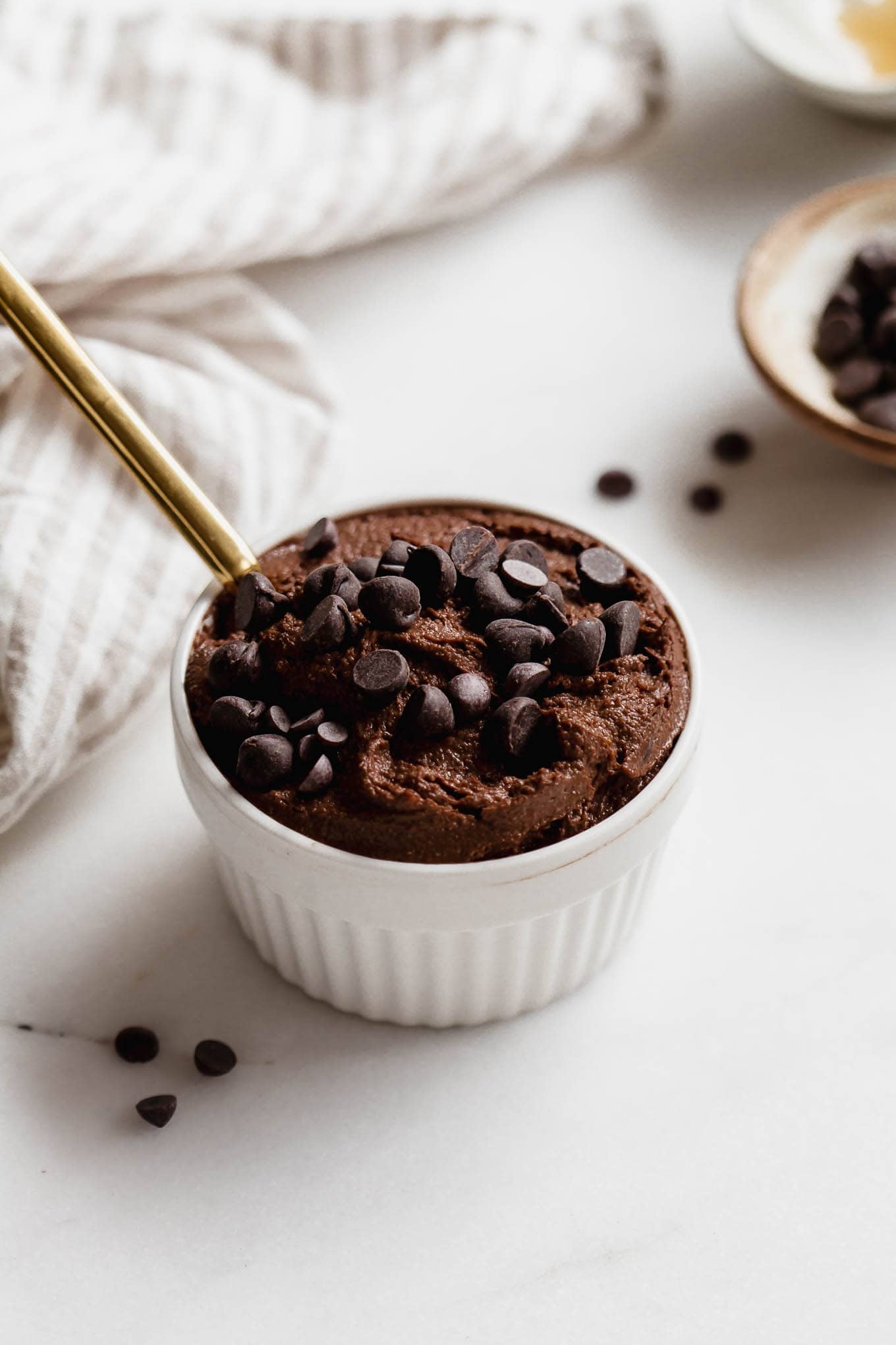 Delicious chocolate chia pudding topped with chocolate chips in a white ramekin.