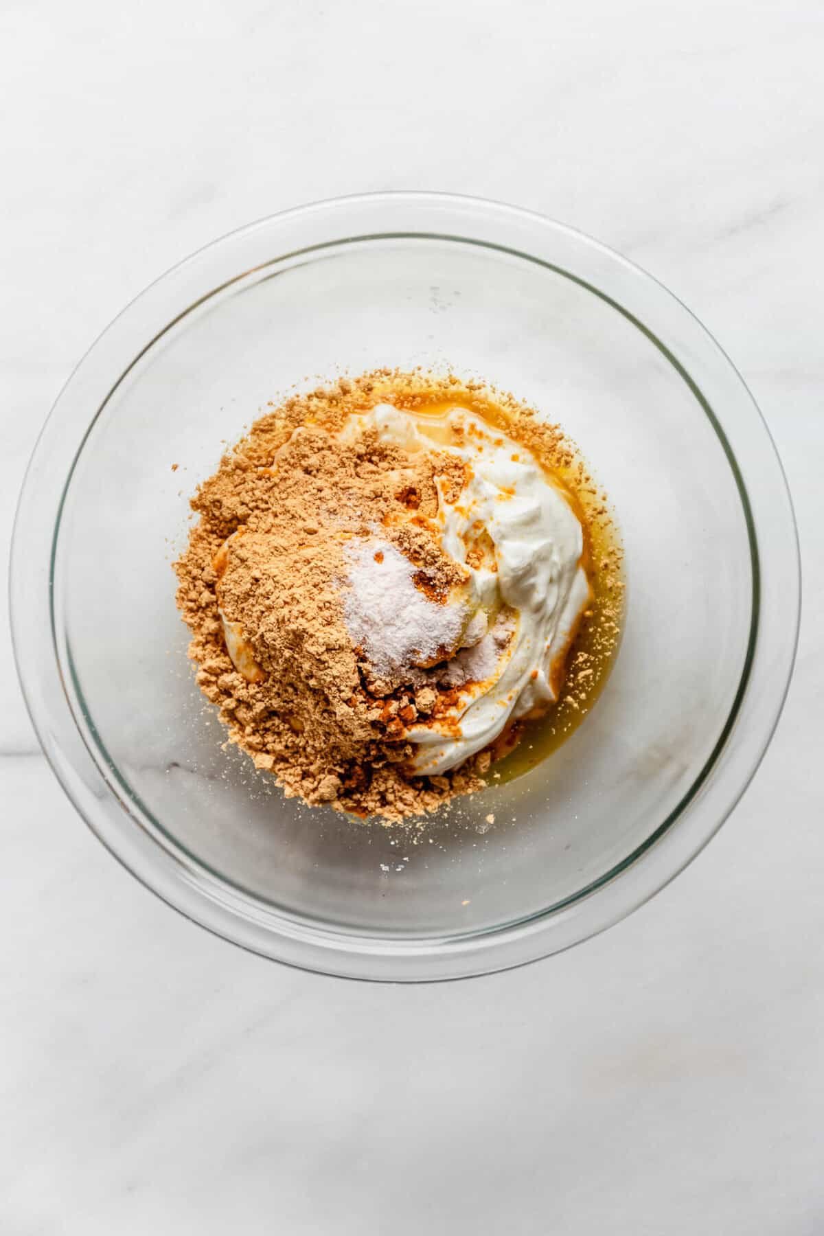Bowl of Greek yogurt, peanut butter powder, and honey before mixing into mousse.