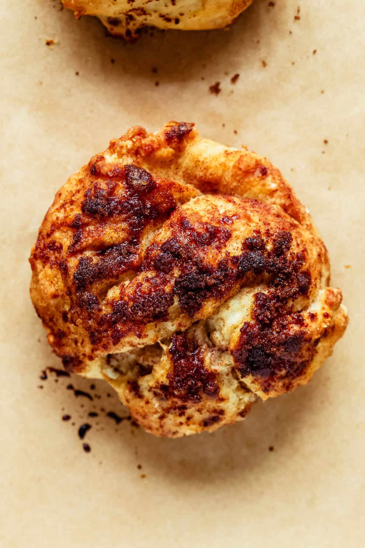 Overhead close-up of a cottage cheese cinnamon crunch biscuit showing its spiral swirl of cinnamon sugar