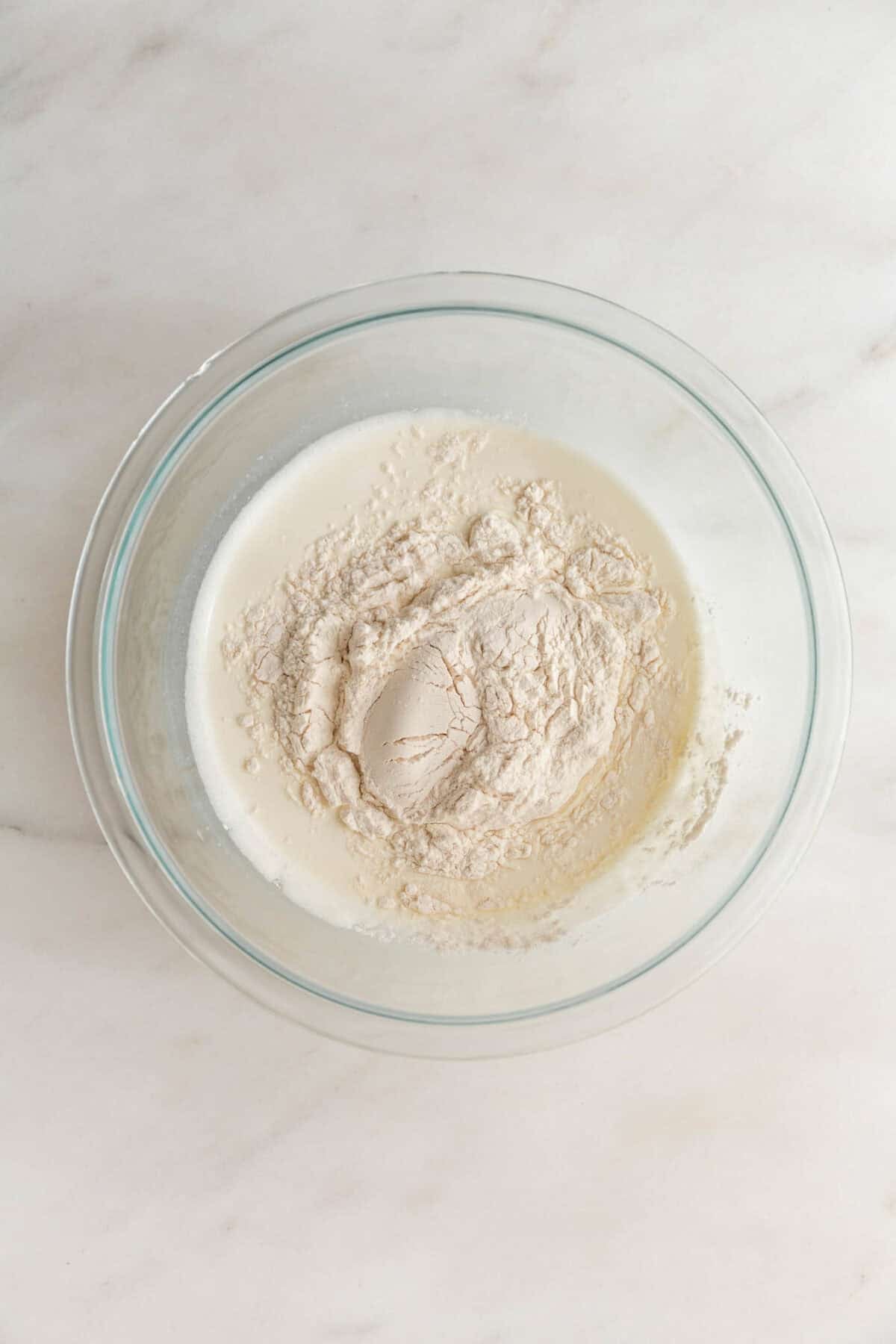 Chia seeds soaking in milk in a glass bowl for healthy recipes.