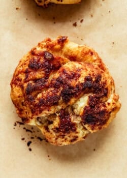 Overhead close-up of a cottage cheese cinnamon crunch biscuit showing its spiral swirl of cinnamon sugar