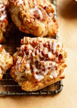 Close-up of glazed cottage cheese apple fritters stacked on a cooling rack.
