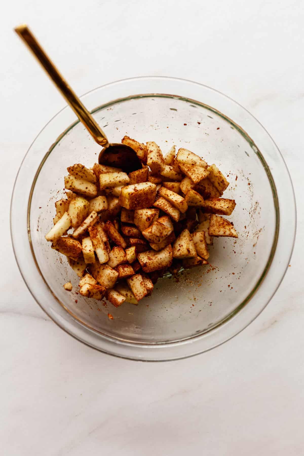 Bowl of diced apples tossed in cinnamon before being mixed into the fritter batter.