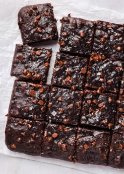 Banana brownies sliced into a grid of squares on parchment paper