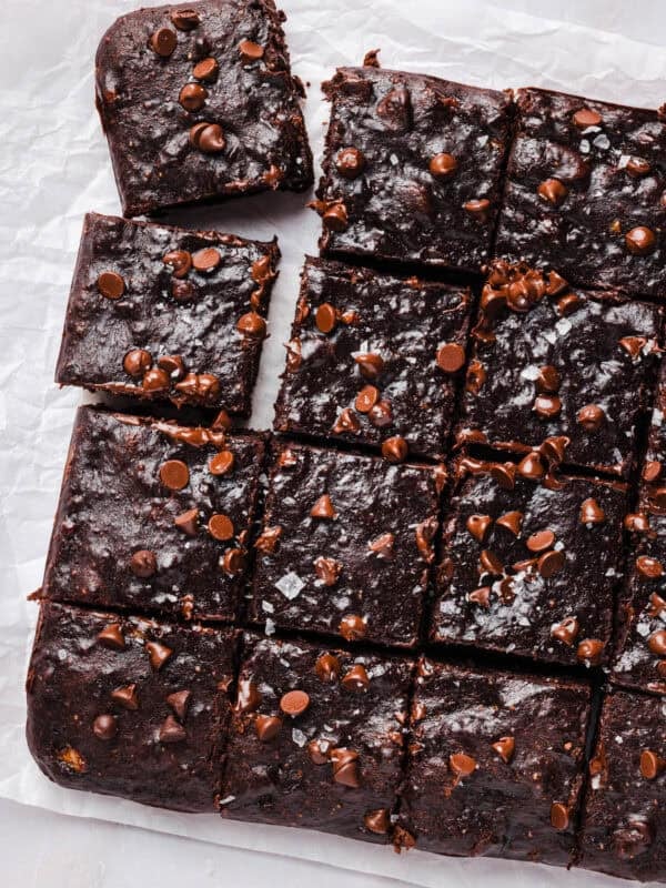 Banana brownies sliced into a grid of squares on parchment paper
