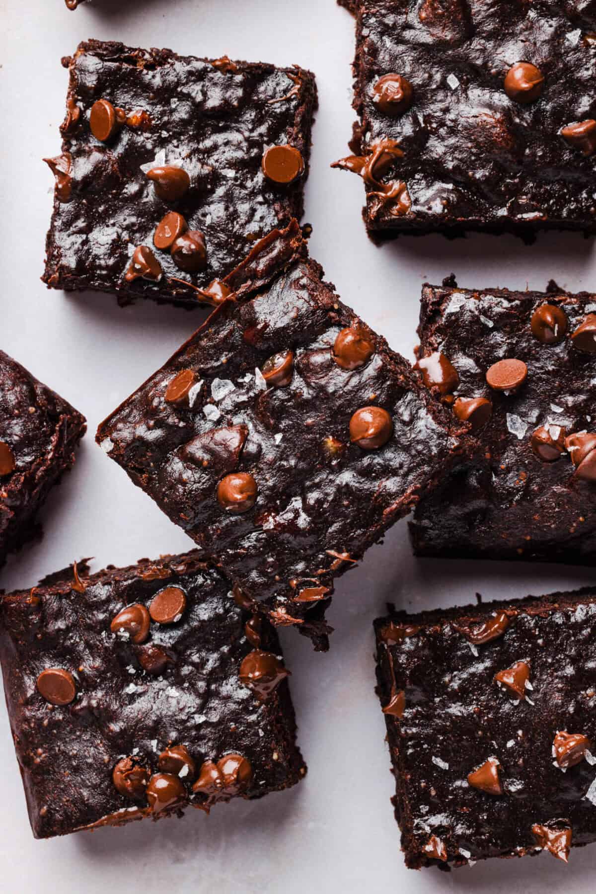 Overhead close-up of fudgy banana brownie squares with chocolate chips on parchment