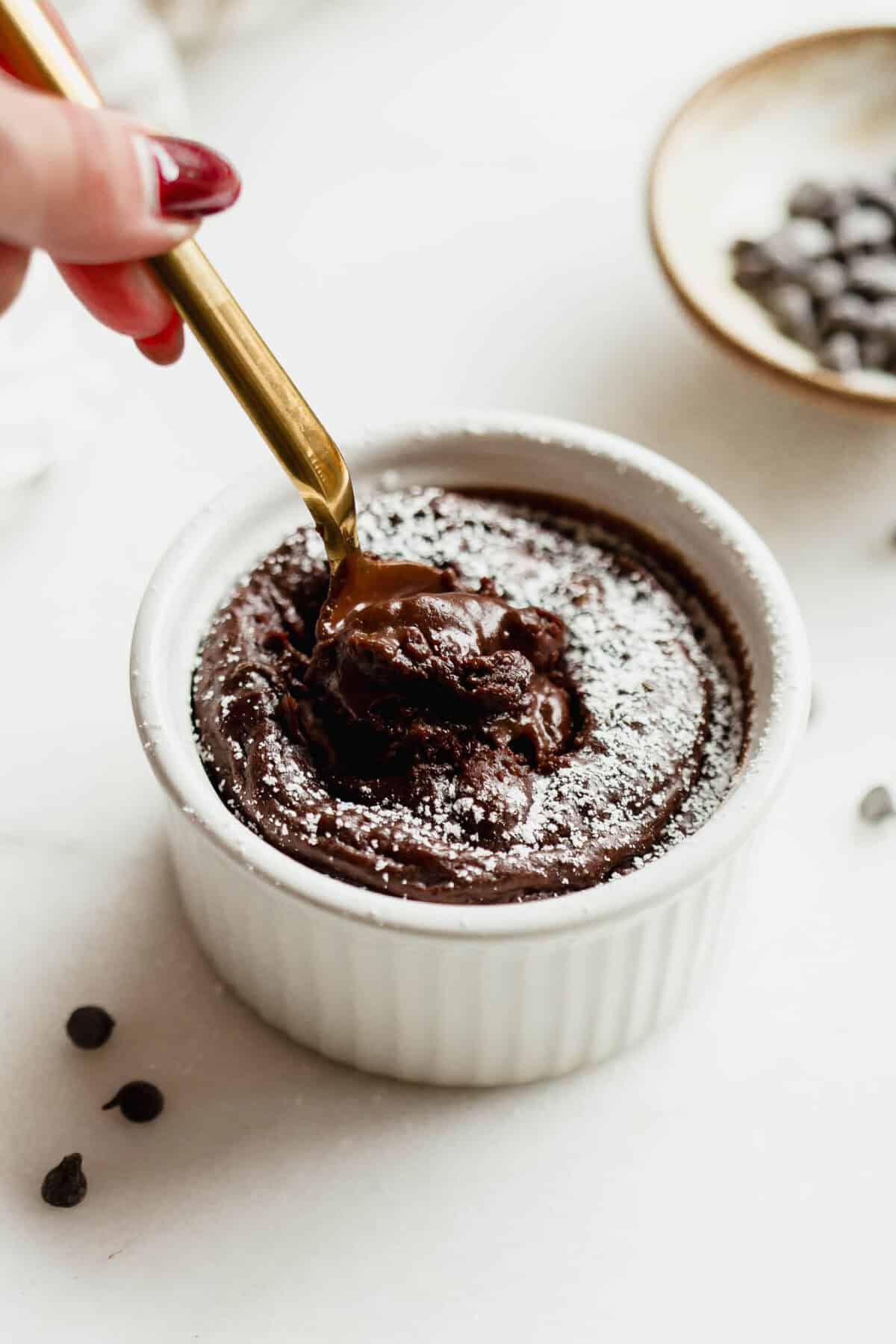 Gold spoon digging into a cottage cheese chocolate lava cake, revealing the molten chocolate center.