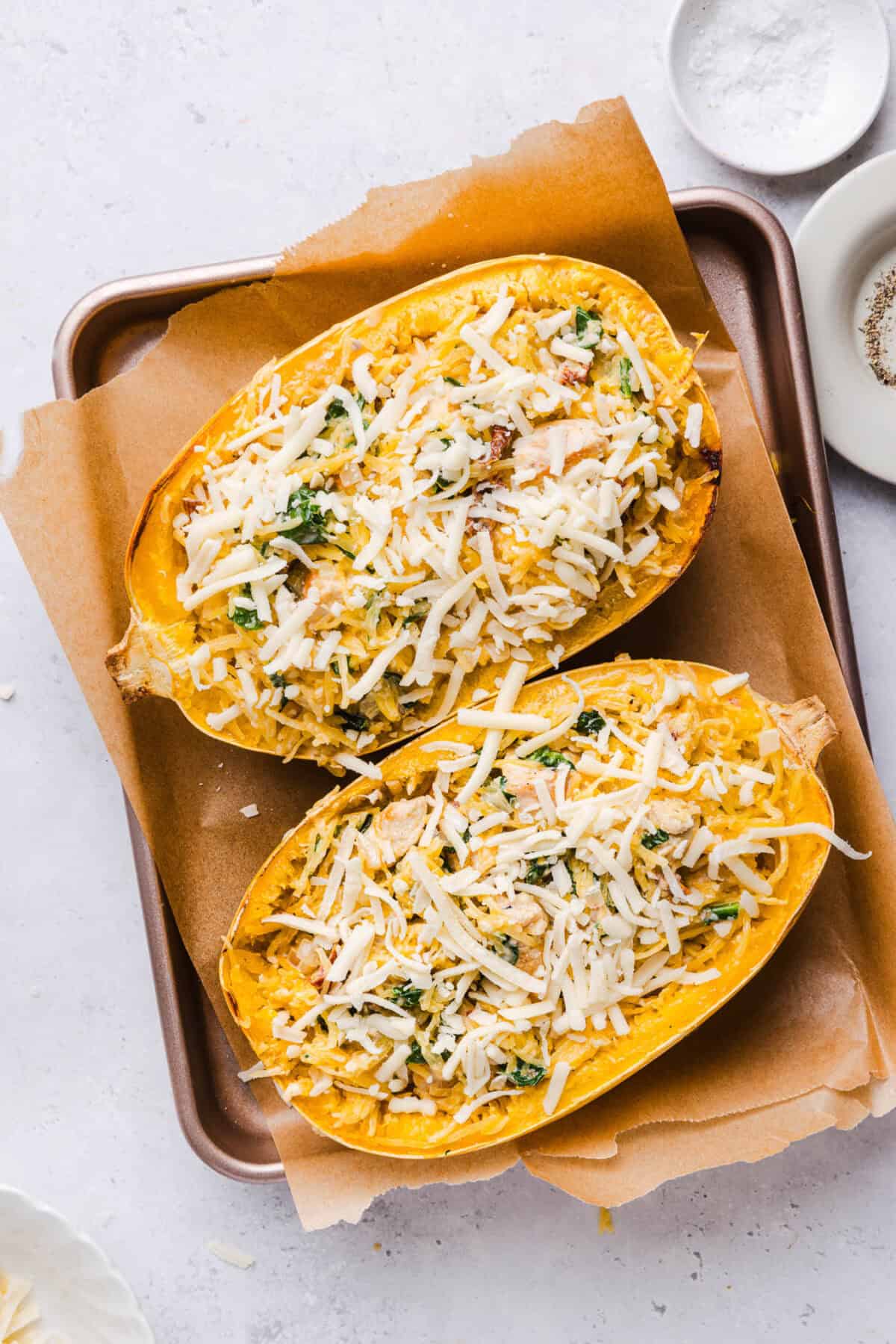 Spaghetti squash halves stuffed with creamy chicken filling and topped with shredded mozzarella before baking